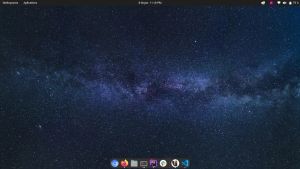 Captura de tela do meu desktop Linux. É exibido a barra superior, a dock com os apps abertos na parte inferior e um papel de parede de galáxia.